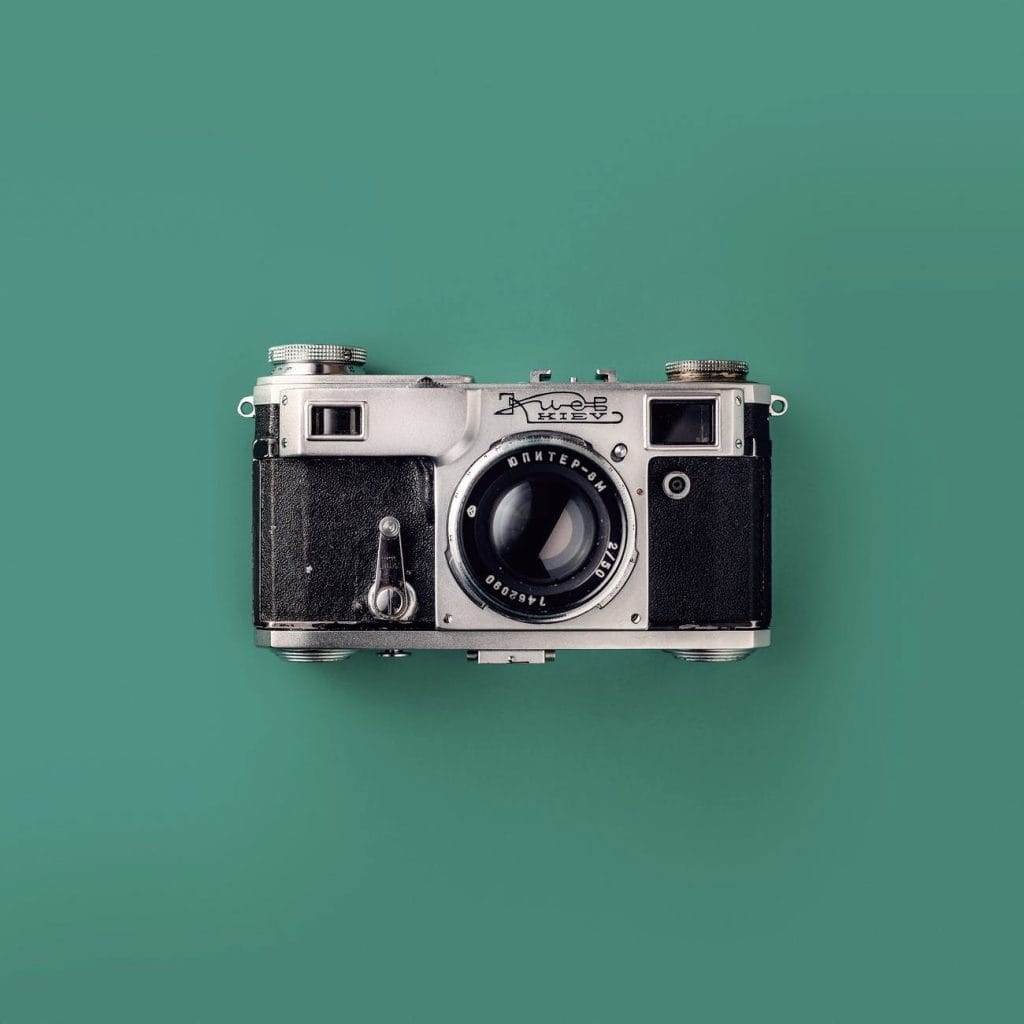 grey and black camera on green background