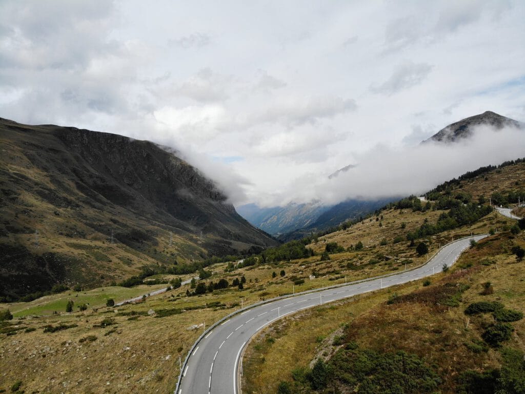 scenic landscape of road in mountainous valley against misty sky
