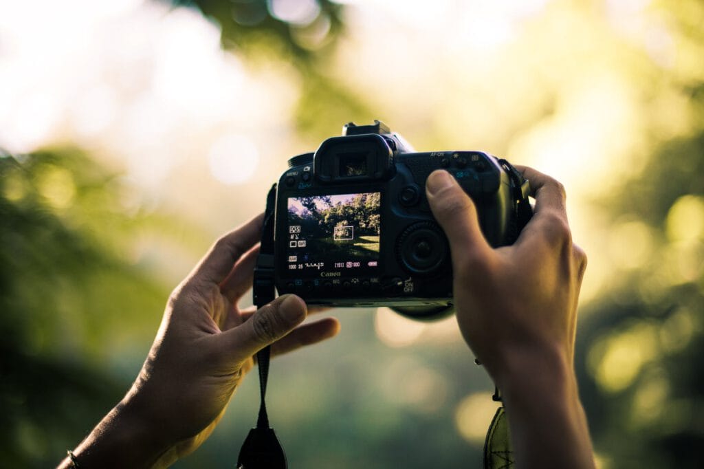 person holding dslr camera selective focal photo